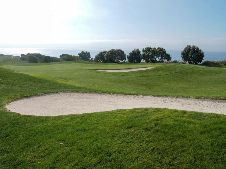 A gold course with a sand trap.