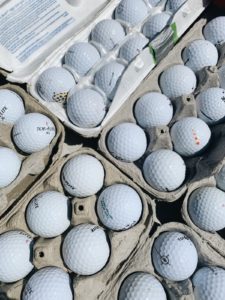 Cardboard egg cartons filled with golf balls.
